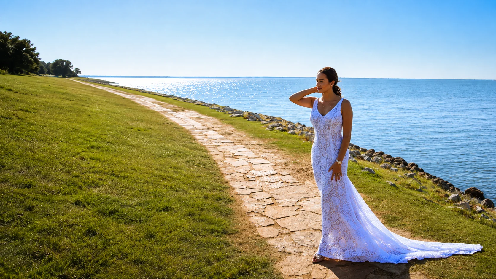 A DORDO client wearing a white lace gown beside the sea