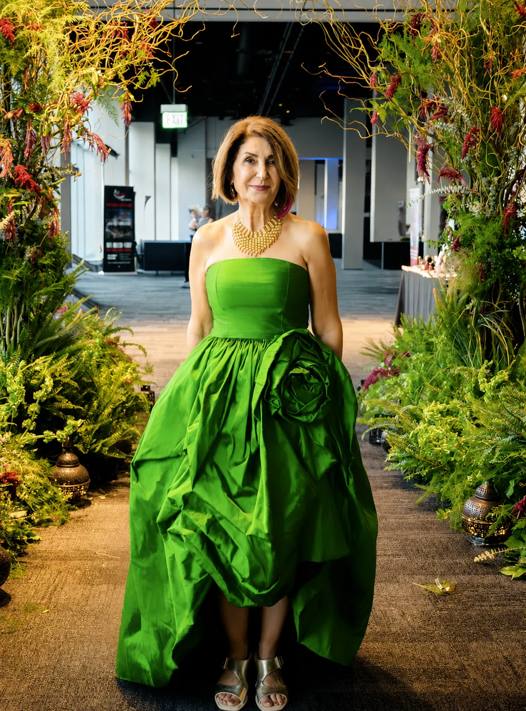 A client wearing a vivid green sculptural dress