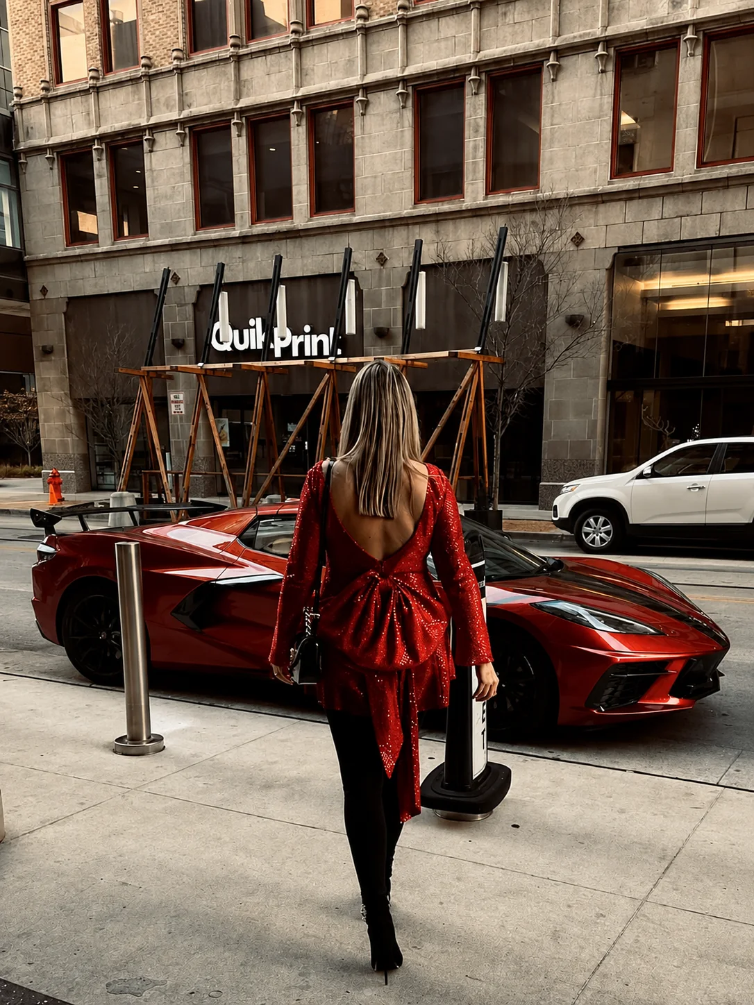 A client wearing a dramatic red fashion look in the city